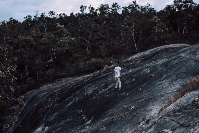 image-56 Mysterious man in mask on rocky formation in forest