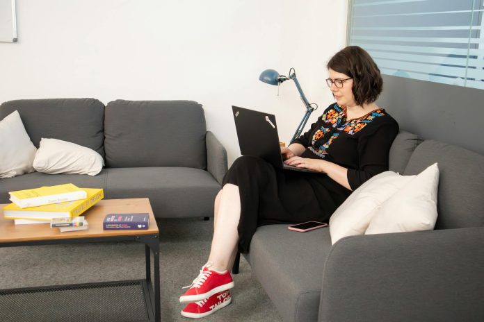 image-88 A person working on their laptop while seated on a sofa in a coworking office