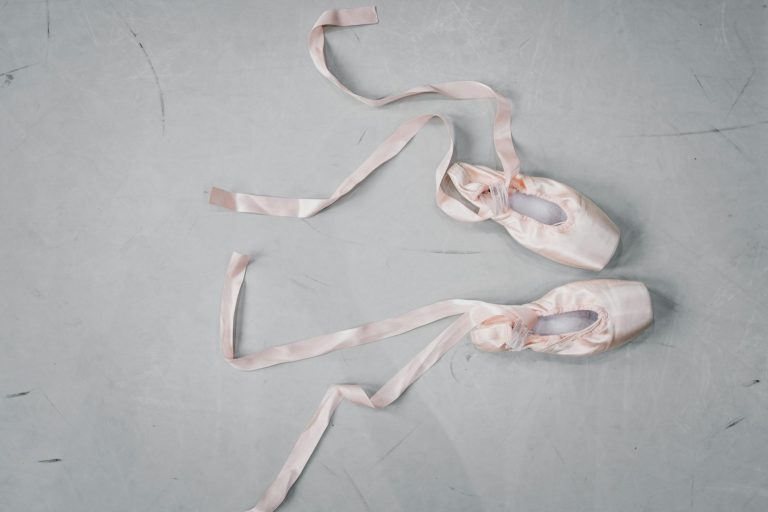 Light pink pointe shoes on floor