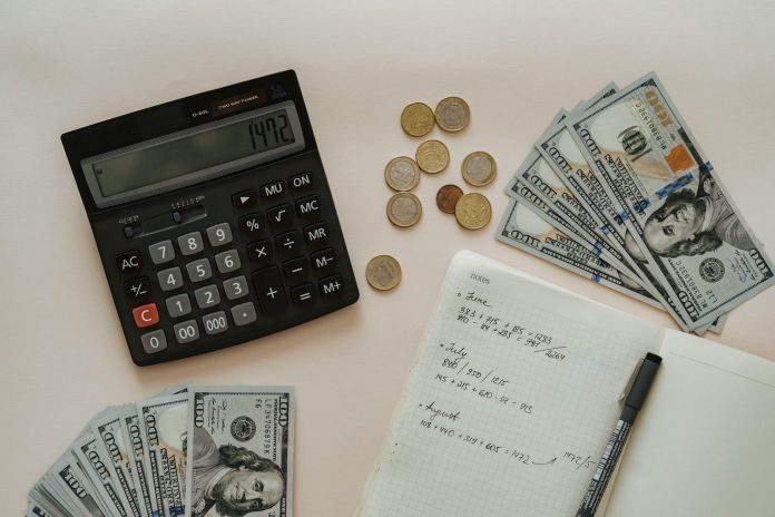 image-122 Black Calculator beside Coins and Notebook