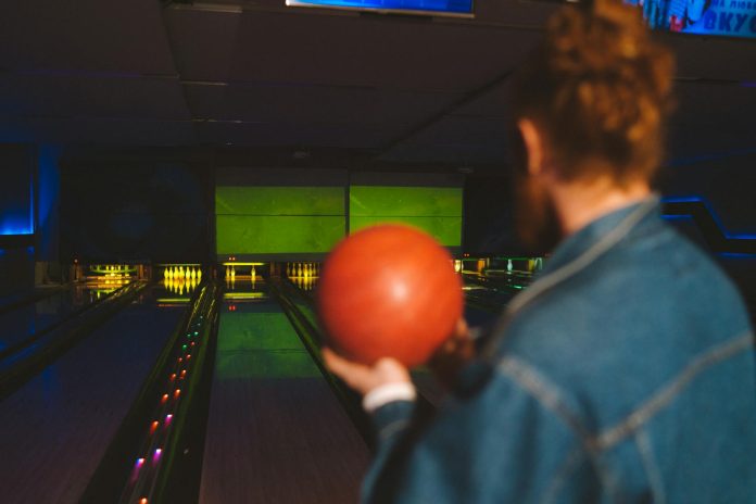 image-135 A Man Holding a Bowling Ball While Standing on the Bowling Lane