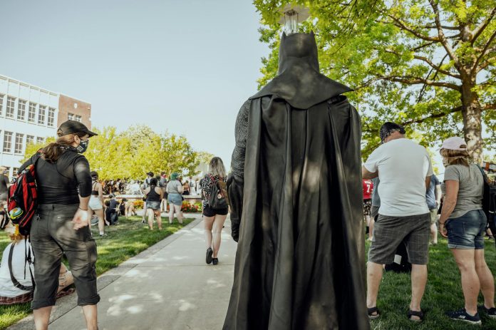 Anonymous person in superhero costume walking in park