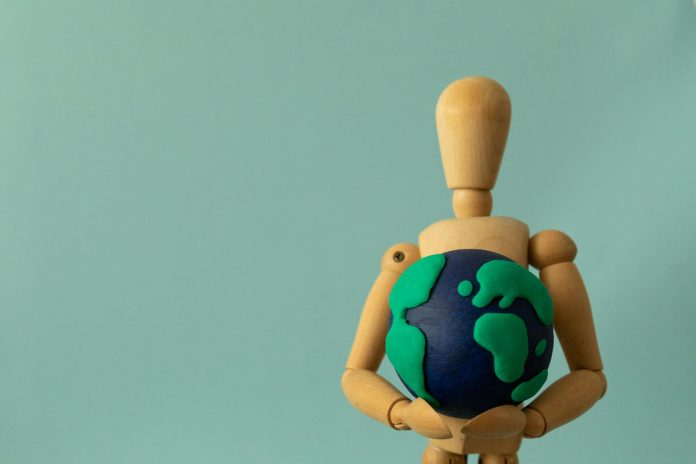image-68 Plasticine Earth in the Hands of a Wooden Puppet