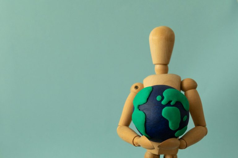 Plasticine Earth in the Hands of a Wooden Puppet