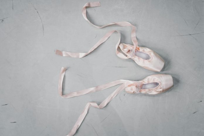 Light pink pointe shoes on floor