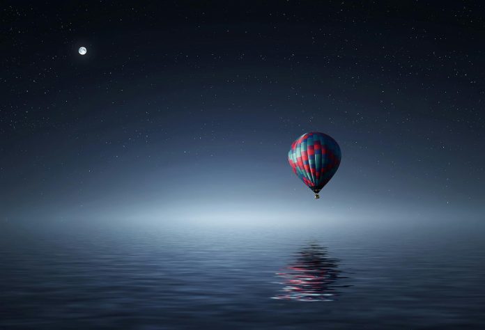 image-25 Red and Blue Hot Air Balloon Floating on Air on Body of Water during Night Time